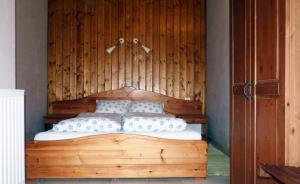 a bedroom with a wooden bed with two pillows at Dorka vendégház in Kehidakustány