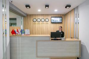 a woman sitting at a desk with a computer at Astra City Hotel in Almaty