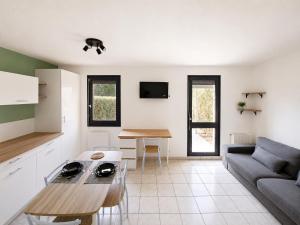 a living room with a couch and a table at Studio avec terrasse et jardin privatif - Figeac centre - Parking gratuit in Figeac