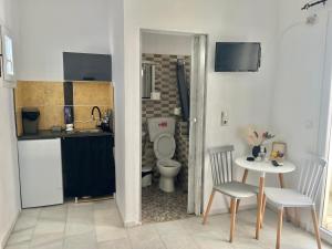 a bathroom with a toilet and a table and chairs at Studios Zafiri in Naxos Chora +50 photos