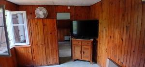 a living room with a television and a wooden wall at Studio privatif in Figeac