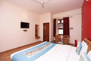 a bedroom with a bed and a tv on the wall at hotel gsa & guest house in Haridwār