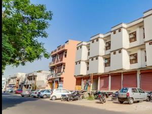 a row of buildings on a street with parked cars at hotel gsa & guest house in Haridwār