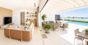 a living room with a couch and a tv at Villa Ainé Luxury Villa, Sea Views, Heated pool in Puerto Calero