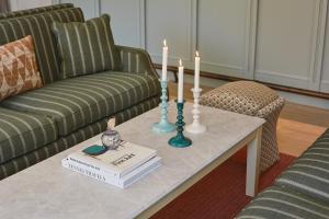 a coffee table with a book and candles on it at Henriks Hotel in Copenhagen