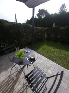 a table with a plant and an umbrella on a patio at Studio avec terrasse et jardin privatif - Figeac centre - Parking gratuit in Figeac