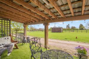 a patio with chairs and a bench and a field at 1 Bed in Tilbrook oc-a40241 in Tilbrook +22 photos