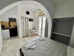 a bedroom with a bed and a kitchen with a table at Studios Zafiri in Naxos Chora