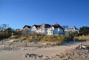 uma casa grande situada no topo de uma praia de areia em Promenadenhotel Admiral em Bansin