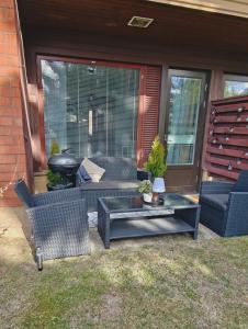 a patio with chairs and a table and a grill at Sorvarinraitin sydän in Seinäjoki