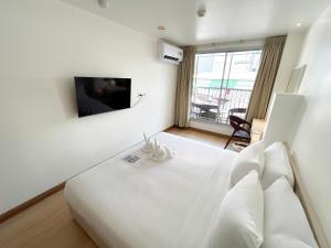a hotel room with a white bed and a window at Taradii Boutique in Bangkok