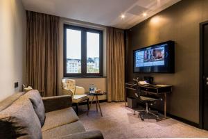a living room with a couch and a desk and a tv at Montcalm Royal London House, London City in London