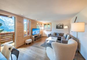 a living room with a couch and a tv at Chalet Rubi in Wengen