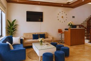 a living room with blue couches and a tv at Tam Coc Sylvani Homestay in Vũ Lâm
