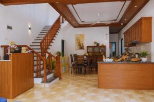 a kitchen and dining room with a staircase in a house at Tam Coc Sylvani Homestay in Vũ Lâm