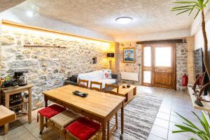 a living room with a table and a stone wall at Limni Stone Apartments in Límni