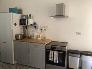 a kitchen with a stove and a refrigerator at Door Nine -Townhouse with harbour views in Il-Furjana