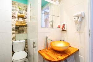 a bathroom with a bowl sink and a toilet at Limni Stone Apartments in Límni +37 photos