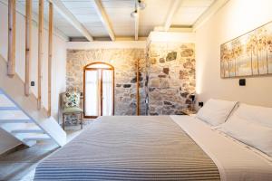 a bedroom with a bed and a stone wall at Limni Stone Apartments in Límni