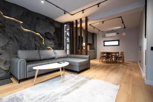 ein Wohnzimmer mit einer Couch und einer Steinwand in der Unterkunft Sky Nest Chalets in Buşteni
