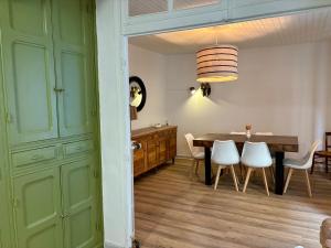 a dining room with a table and white chairs at Chez le Sabotier, central et confortable in Rosières