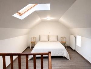 a bedroom with a white bed and a skylight at Chez le Sabotier, central et confortable in Rosières +7 photos