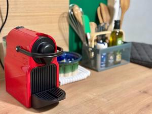 a red appliance sitting on top of a wooden table at Chez le Sabotier, central et confortable in Rosières