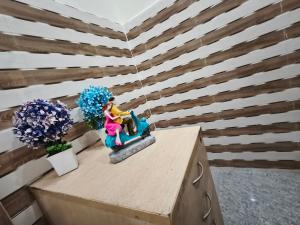 Eine Figur einer Frau, die auf einem Tisch mit Blumen sitzt in der Unterkunft Hotel come inn in Palwal