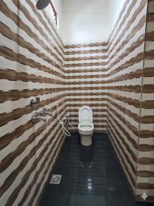 ein Badezimmer mit Toilette in einem Zimmer mit Holzwänden in der Unterkunft Hotel come inn in Palwal