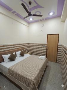ein Schlafzimmer mit Bett und Deckenventilator in der Unterkunft Hotel come inn in Palwal