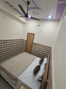 ein Bett in einem Zimmer mit Deckenventilator in der Unterkunft Hotel come inn in Palwal