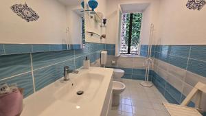 a blue and white bathroom with a sink and a toilet at Complesso Villa Le Palme in Forio d'Ischia +89 photos