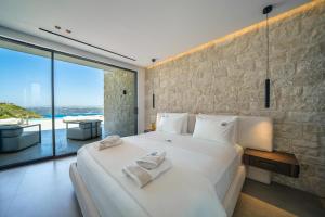 ein Schlafzimmer mit einem großen weißen Bett und einem großen Fenster in der Unterkunft Creticum Mare in Chania