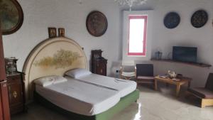 a bedroom with a bed in a room with clocks on the wall at La casa di Aurora - Room A - Boutique Hotel in Agios Ioannis Peristerion