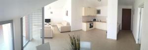 a white kitchen and living room with a couch at Acacia Hills D8 in Herceg Novi in Herceg-Novi
