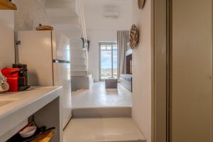 a kitchen with a white refrigerator and a hallway at Jo&Co Mykonos Nature Suites N3 in Plintri +17 photos