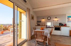 a kitchen and dining room with a table and a balcony at Gite DURANCE in Mallemort