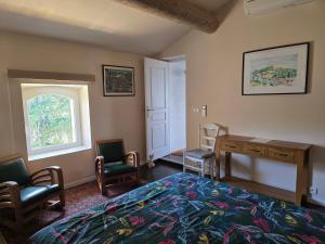 a bedroom with a bed and a desk and chairs at Gite DURANCE in Mallemort