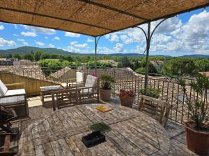 a patio with a table and chairs on a deck at Gite DURANCE in Mallemort