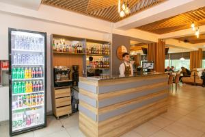 a man standing at a bar in a restaurant at Astra City Hotel in Almaty