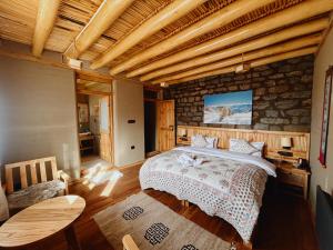 a bedroom with a bed and a stone wall at Shan at Uley in Leh