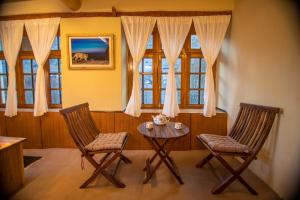 a room with two chairs and a table and a window at Shan at Uley in Leh