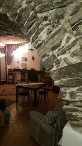 emy lake orta في بيلا: غرفة مع طاولة وجدار حجري