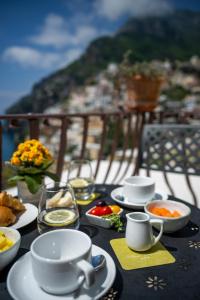 a table with cups and plates of food on a balcony at Albergo California in Positano