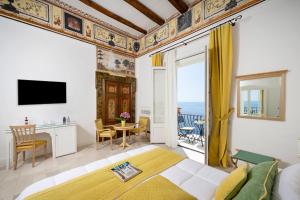 a bedroom with a king sized bed and a balcony at Albergo California in Positano