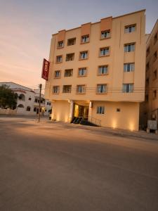 a hotel building with the sunset in the background at RED algarbeia in Salalah