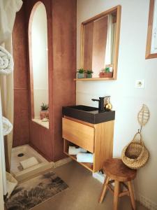 a bathroom with a sink and a mirror and a stool at La Petite Escale in Lunel +20 photos