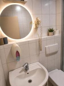 a white bathroom with a sink and a mirror at Hotel Panorama Nickenich in Nickenich +24 photos