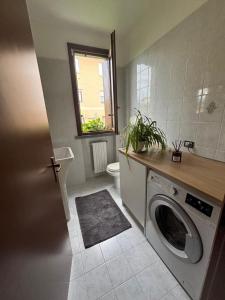 a bathroom with a washing machine and a window at Como Gate - 10 minuti dal centro in Lucino