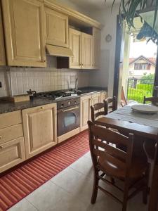 a kitchen with wooden cabinets and a table and a stove at Como Gate - 10 minuti dal centro in Lucino